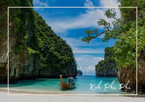 Maya Bay in Thailand wirkt wie eine geschützte Bucht aus einem Bilderbuch: links und rechts steigen grüne Felswände steil auf und rahmen das ruhige, türkisfarbene Wasser ein. Im Vordergrund liegt der helle Sand fast wie ein weicher Saum am Ufer, während das Meer sanft und klar in der Mitte der Bucht schimmert. Über der Szene spannt sich ein blauer Himmel mit leichten Wolken, der die ganze Landschaft frisch, offen und paradiesisch erscheinen lässt.
