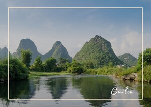 Die Landschaft spiegelt sich wunderbar in dem Li-Fluss. Die drei Hügel schmiegen sich perfekt in die grüne Karstlandschaft und die Reisplantagen.