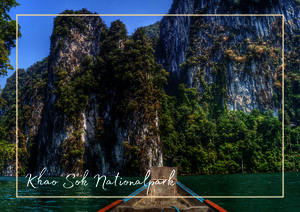 Khao Sok National Park wirkt wie eine grüne Wand aus Felsen und Urwald, die sich steil aus dem Wasser erhebt. Im Vordergrund schimmert das Wasser ruhig und türkis, während die hohen Kalksteinformationen wie uralte Wächter über der Landschaft stehen. Die Mischung aus dichtem Dschungel, schroffen Gipfeln und der stillen Wasserfläche macht die Szene wild, tief und eindrucksvoll.