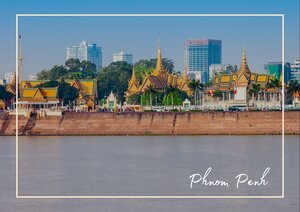 Eine wunderschöne Uferpromenade vor Phnom Penh mit mehreren goldenen Pagoden und Tempeldächern erstreckt sich entlang des breiten Flusses, im Hintergrund sind moderne Hochhäuser zu sehen. Das Bild zeigt den Kontrast zwischen traditioneller Architektur und der modernen Skyline bei klarem Tageslicht.