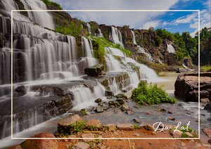 Da Lat zeigt hier seine grüne, wasserreiche Seite: Ein breiter Wasserfall fällt in mehreren Stufen über die Felsen und zieht dabei einen hellen, bewegten Schleier durch die Landschaft. Im Vordergrund liegen nasse Steine und kleine Pflanzen, während oben dichtes Grün und offener Himmel die Szene freundlich und frisch wirken lassen. So entsteht ein ruhiges, naturverbundenes Bild, das Da Lat sehr stimmungsvoll beschreibt.