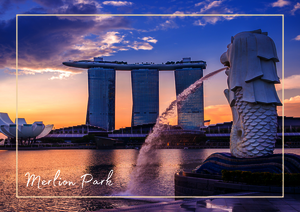 In Marina Bay, Singapur spiegeln sich die Lichter der Skyline im Wasser und betonen die moderne Silhouette der Stadt. Im Vordergrund setzt die markante Form des Merlion einen typischen Akzent, während das sanfte Abendlicht der Szene einen besonders schönen Rahmen gibt. Das Zusammenspiel aus Architektur, Wasser und Himmel macht den Ort sofort wiedererkennbar.