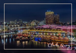 Am Clarke Quay in Singapur spiegeln sich die bunten Lichter der Uferpromenade im Wasser und verleihen der Szene eine lebendige, nächtliche Atmosphäre. Die beleuchteten Gebäude und Boote sorgen für ein farbenreiches Stadtbild, das besonders im Dunkeln eindrucksvoll zur Geltung kommt.