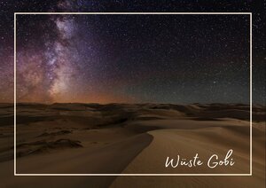 Die Wüste Gobi wird im warmen Abendlicht beschienen, während die Sanddünen und Hügel weich in den Schatten übergehen. Am Himmel leuchtet noch der letzte Farbverlauf des Sonnenuntergangs, und darüber spannt sich ein klarer Sternenhimmel. Die weite, stille Landschaft wirkt dadurch besonders offen und eindrucksvoll.