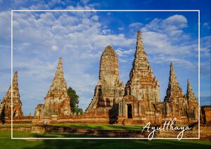 Die alten Tempeltürme von Ayutthaya steigen wie steinerne Kronen aus der Ebene empor und wirken im warmen Licht fast ehrwürdig und zeitlos. Über ihnen spannt sich ein weiter Himmel mit sanften Wolken, der die roten Backsteine und goldbraunen Mauern noch kräftiger leuchten lässt. Dadurch bekommt die Szene eine ruhige, geschichtsträchtige Atmosphäre, die gleichzeitig kraftvoll und friedlich wirkt.