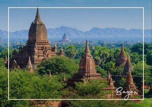 Die Pagoden von Bagan ragen zwischen dichtem Grün und sanften Hügeln in die Landschaft hinein. Im Hintergrund öffnet sich eine weite Ebene mit weiteren Tempeln, die der Szene eine historische Tiefe geben.